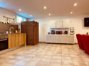 a kitchen with white cabinets and a red couch at Villa Horta in Horta