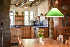 a kitchen with a wooden table and a green lamp at Berghof Papstdorf in Kurort Gohrisch +14 photos
