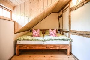 a bed in a room with a wooden ceiling at Berghof Papstdorf in Kurort Gohrisch