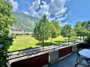 a balcony with a view of a field and mountains at APARTMENT Alessio in Interlaken