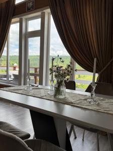 a dining room table with a vase of flowers on it at lovelaz820 in Khashchovanoye