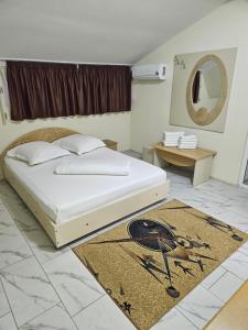 a bedroom with a bed and a rug on the floor at Casa Andreea in Eforie Sud