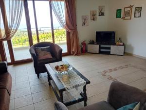 a living room with a coffee table and a tv at Κτήμα Verde in Agia Paraskevi