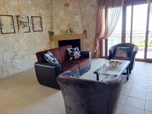 a living room with a couch and chairs and a table at Κτήμα Verde in Agia Paraskevi