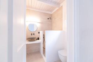 a bathroom with a toilet and a mirror at Drio Kythnos Suites in Dhriopís +42 photos