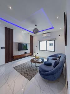 a living room with a blue couch and a table at Luxury Executive Balcony Suite at THE HIDDEN DOMUS I Elmina Suite in Accra