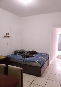 a bed in a white room with a bedvisor at Kitnet Unip Mandic in Campinas
