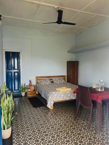 a bedroom with a bed and a table and chairs at Org Retreat & Farmstay in Guwahati