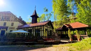 a building with a clock tower on top of it at Stavilar Hotel - Charming Stay Just Steps Away from Peles Castle in Sinaia in Sinaia