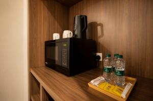a microwave and two bottles of water on a shelf at Eliana Hotel in Al Khobar