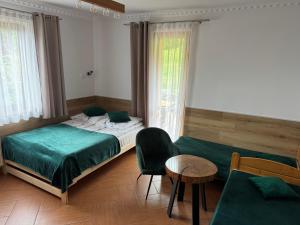 a bedroom with a bed and a chair and a table at Agroturystyka Kadłubek in Wisła +42 photos