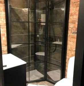 a bathroom with a glass shower with a toilet at Kronan Bed & Breakfast in Vara