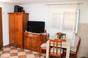 a living room with a table and a tv and a table and chairs at Bellora Studio House in Donja Jošica