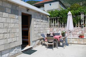 a patio with a table and chairs and an umbrella at Bellora Studio House in Donja Jošica