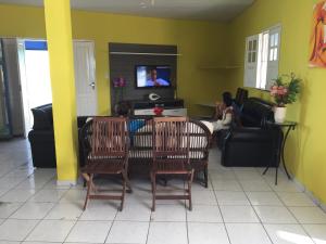 a living room with two chairs and a table and a tv at Pousada Ilha do Sol in Salinópolis