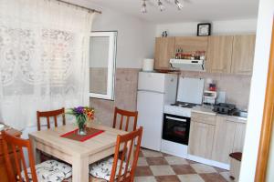 a kitchen with a table with chairs and a refrigerator at Bellora Studio House in Donja Jošica +9 photos