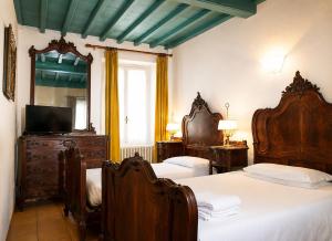 a bedroom with two beds and a television in it at Albergo dell'Angelo in Pieve di Teco