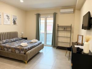 a bedroom with a bed and a desk and a television at Volare B&B in Reggio di Calabria