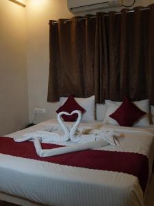 a bed with two swans made out of towels at Hotel Trimurti Executive in Dāpuri