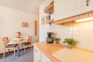 a kitchen with a counter and a table with chairs at Ostseeglück App Mittagsonne in Loddin