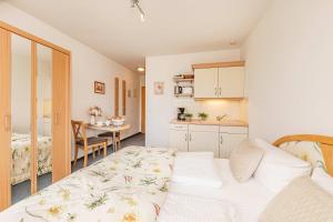 a small room with a bed and a kitchen at Ostseeglück App Mittagsonne in Loddin
