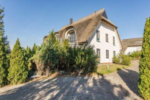 a large white house with a pointed roof at Ostseeglück App Mittagsonne in Loddin