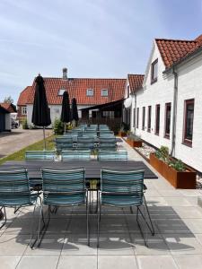 a long table with chairs and umbrellas on a patio at Ibsens Gaard in Ebeltoft