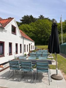 a group of chairs and a table with an umbrella at Ibsens Gaard in Ebeltoft