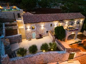 an aerial view of a stone house with lights at Heritage House Strahinja Stone Villa with Private Pool in Popovići