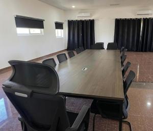 a conference room with a large wooden table and chairs at Hotel Residencial Assamar in Pemba