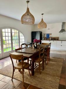 a dining room with a wooden table and chairs at La Villa 1777 in Lagnes