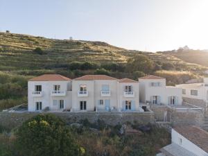 a large white house with a hill in the background at Drio Kythnos Suites in Dhriopís