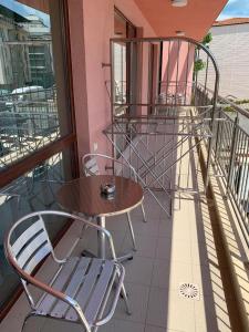 a patio with a table and chairs on a balcony at Cattleya in Nesebar