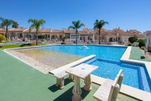 a swimming pool with two chairs in front of a house at CH Logroño Doña Pepa in Rojales