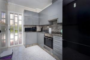 a kitchen with white cabinets and a black refrigerator at CH Logroño Doña Pepa in Rojales