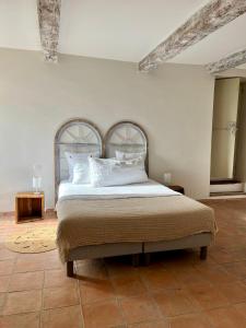 a bedroom with a bed with white sheets and pillows at La Villa 1777 in Lagnes +28 photos