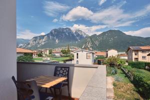 a balcony with a table and chairs and a mountain at Meridiana Gemona in Taboga