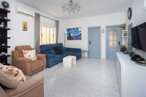 a living room with a blue couch and chairs at CH Logroño Doña Pepa in Rojales