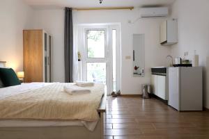 a white room with a bed and a kitchen at Doricera in Kotor
