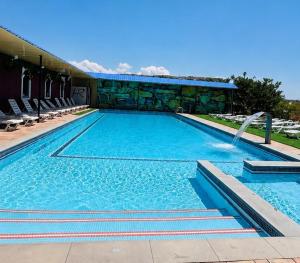 a large swimming pool with a water fountain at Canyon Hills Hotel in Yerevan