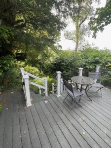 a wooden deck with a table and a table and bench at Beauport Retreat in Hastings