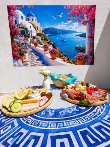 a table topped with plates of food with a picture of a island at Le secret de Santorin in Martigues