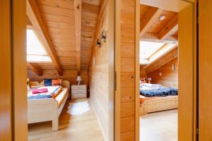 two beds in a room with wooden ceilings at Chalet Regenbogen Familienapartment mit Indoor-Rutschbahn & Spieloase an der Fussgängerzone in Leukerbad +62 photos