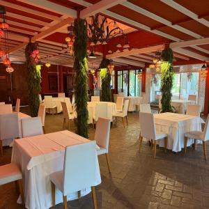 a restaurant with white tables and chairs and plants at Masía De Lacy in Museros