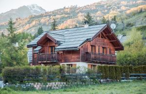 a wooden house with a black roof at Chalet Le Serre des Oiseaux in Saint-Chaffrey