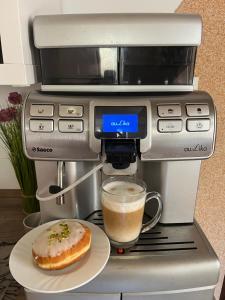 a coffee machine with a cup of coffee and a doughnut at Agroturystyka Kadłubek in Wisła