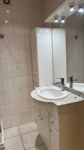 a white bathroom with a sink and a mirror at Boismortier in Thionville