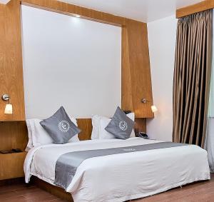 a bedroom with a large bed with blue pillows at La Maison Royale in Nairobi +95 photos