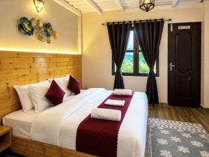 a bedroom with a large bed with two towels on it at The Hills Boho in Mukteshwar