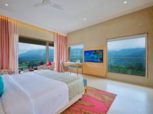 a bedroom with a bed and a desk and windows at Vibe Munnar Resort & Spa in Munnar +72 photos